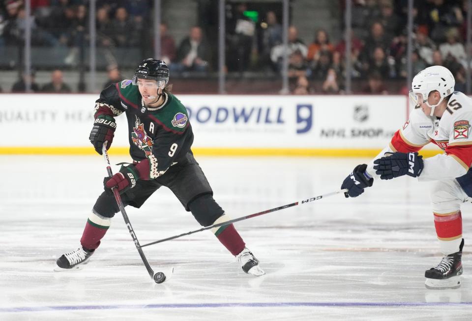 Arizona Coyotes right wing Clayton Keller (9) looks to pass while defended by Florida Panthers center Anton Lundell (15) during the second period at Mullett Arena in Tempe on Jan. 2, 2024.