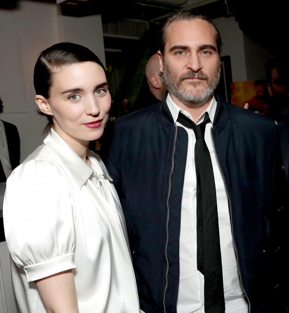 Joaquin Phoenix, putting on a casual wear, as he poses for the camera with a young lady 