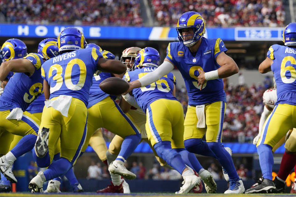 Los Angeles Rams quarterback Matthew Stafford, right, hands off to running back Ronnie Rivers during the second half of an NFL football game against the San Francisco 49ers Sunday, Oct. 30, 2022, in Inglewood, Calif. (AP Photo/Gregory Bull)