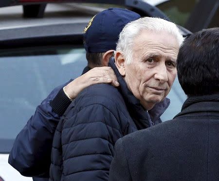 Argentine businessman Hugo Jinkis,who is wanted by U.S. prosecutors in a FIFA bribery investigation, is escorted by a police officer after he turned himself, alongside his son Mariano, in to authorities in Buenos Aires, Argentina, June 18, 2015.REUTERS/Enrique Marcarian