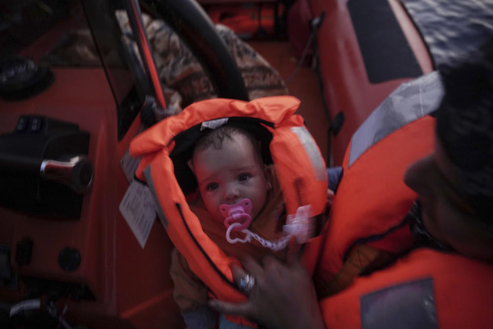 In this Sept. 19, 2019 photo, 4-month-old Mira is held by her mother during a rescue by the Ocean Viking humanitarian ship in the Mediterranean Sea. Her mother says their family escaped Libya after their home was destroyed in the war. (AP Photo/Renata Brito)