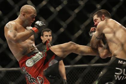 Robbie Lawler, left, kicks Matt Brown during the fifth round of their welterweight fight. (AP)