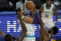 Charlotte Hornets forward P.J. Washington, center, shoots between Golden State Warriors forward Eric Paschall, bottom left, and forward Andrew Wiggins during the first half of an NBA basketball game in San Francisco, Friday, Feb. 26, 2021. (AP Photo/Jeff Chiu)