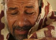 A patient sits in a car wrapped in a blanket after his sand bath treatment in Siwa, Egypt, August 13, 2015. (REUTERS/Asmaa Waguih)