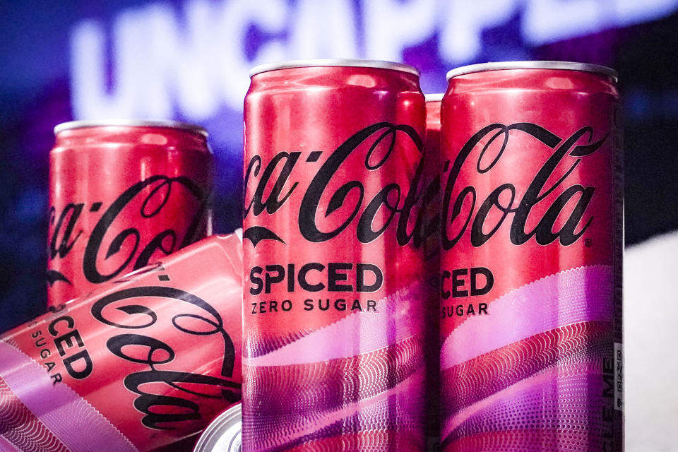 Cans of Coca-Cola Spiced, the beverage company's first new permanent offering to its North American portfolio in three years, are introduced at a livestream media event, Tuesday, Feb. 6, 2024, in New York. (AP Photo/Bebeto Matthews)