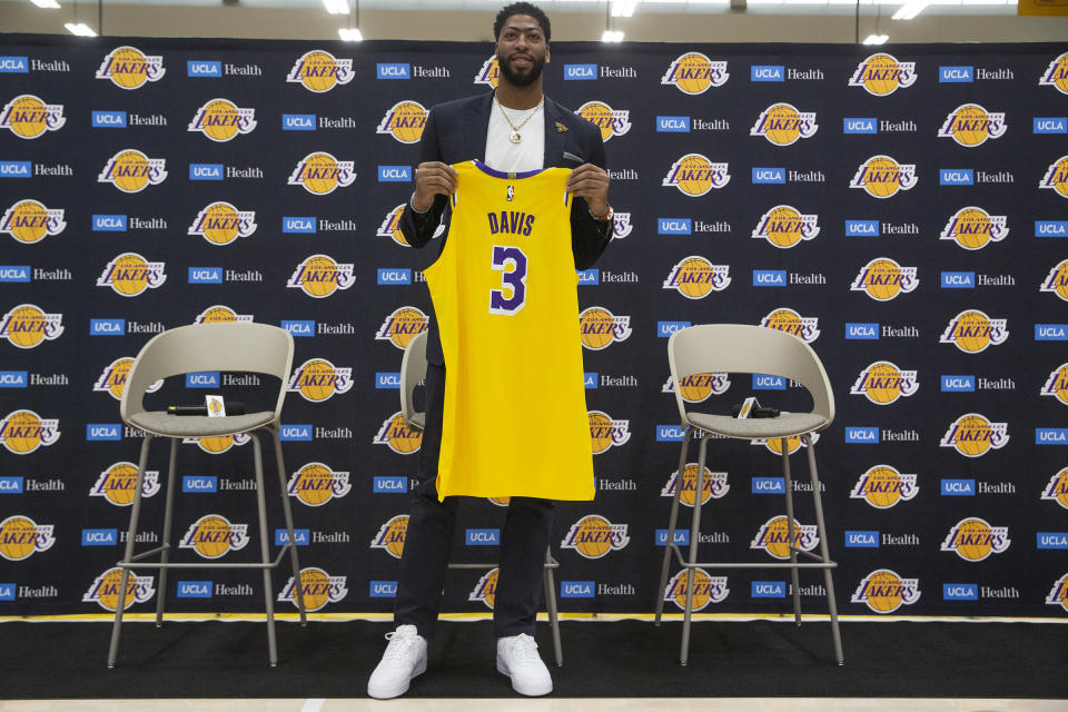 Los Angeles Lakers NBA basketball player Anthony Davis looks down at his number 3 jersey as he is introduced at a news conference at the UCLA Health Training Center in El Segundo, Calif., Saturday, July 13, 2019. The Lakers welcome Anthony Davis to the West Coast in his first public appearance since New Orleans traded the six-time All-Star to Los Angeles to team up with LeBron James. (AP Photo/Damian Dovarganes)