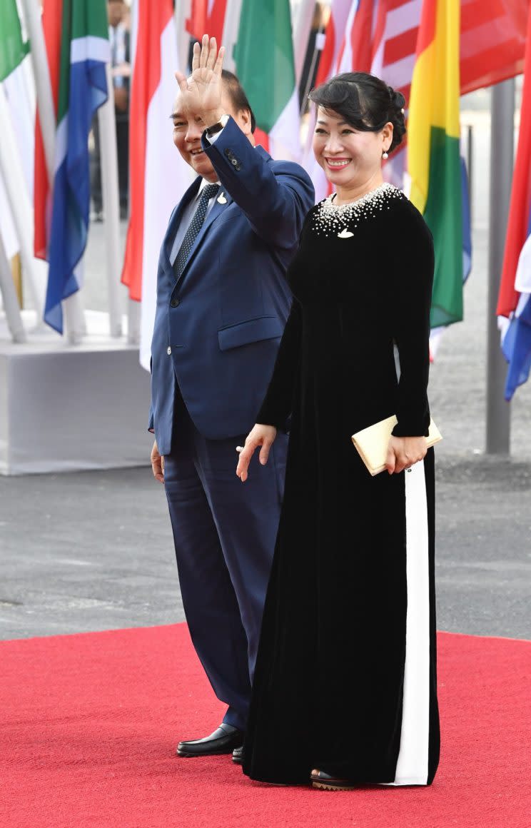 <p>Das Einzige, was man der First Lady Vietnams in ihrer Kleiderwahl vorwerfen könnte, ist der weiße Streifen, der von der Hüfte abwärts bis zum Saum reicht. Aus dieser unvorteilhaften Perspektive könnte man den Streifen aus der Ferne für eine Krücke halten. (Bild: dpa)</p>