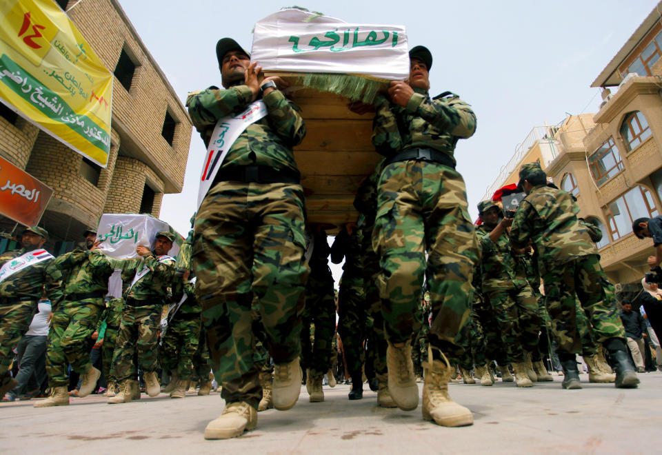 FILE - In this file photo taken Saturday, April 26, 2014, mourners carry the flag-draped coffins of five militia members of a Shiite group, Asaib Ahl al-Haq, or League of the Righteous, during their funeral procession in the Shiite holy city of Najaf, 100 miles (160 kilometers) south of Baghdad, Iraq. As parliamentary elections are held Wednesday, April 30, more than two years after the withdrawal of U.S. troops, Baghdad is once again a city gripped by fear and scarred by violence. (AP Photo/Jaber al-Helo, File)