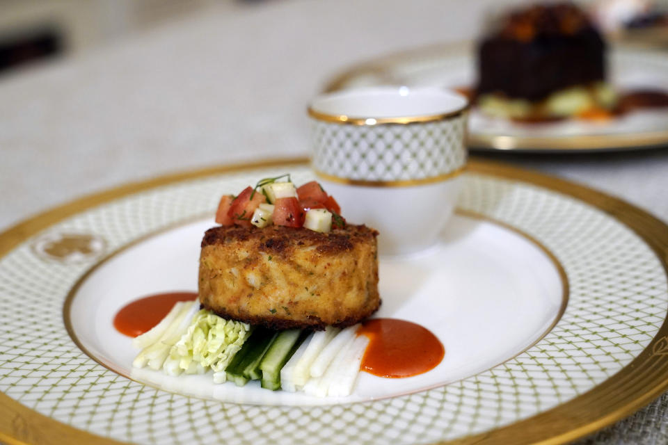 A Maryland crab cake with cabbage, kohlrabi, fennel, and cucumber slaw and a gochujang vinaigrette dish is displayed in the State Dining Room during a media preview, Monday, April 24, 2023, for Wednesday's State Dinner with South Korea's President Yoon Suk Yeol at the White House in Washington. (AP Photo/Susan Walsh)