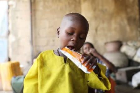 A boy opens his mouth for a bite on a food supplement provided to children at the Banki IDP camp, Borno, Nigeria April 26, 2017. REUTERS/Afolabi Sotunde