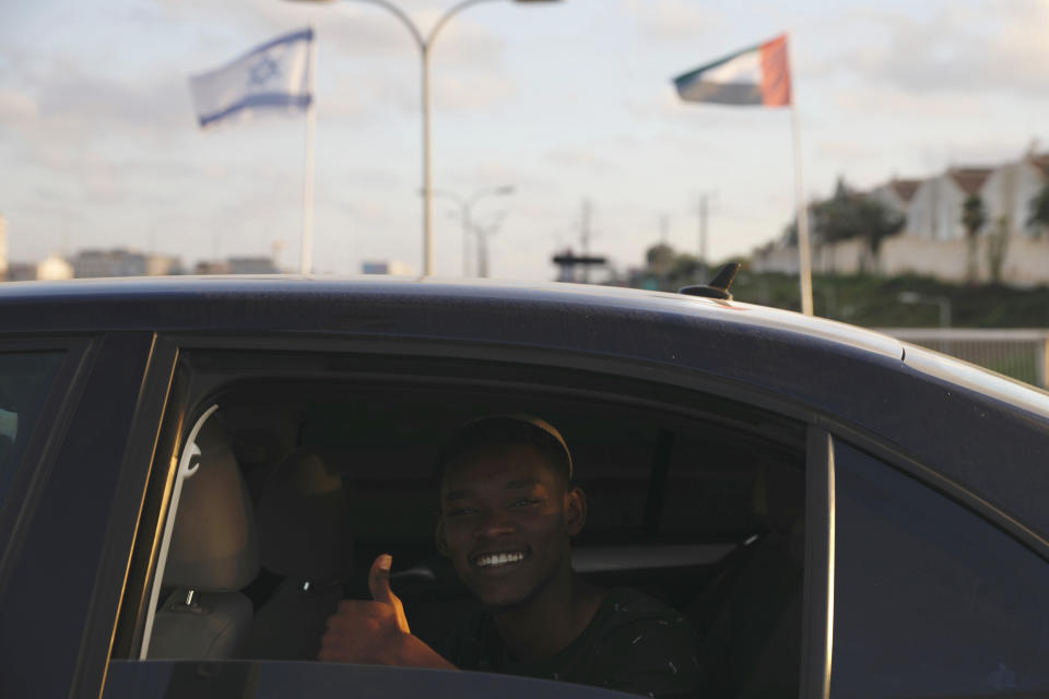 A man gives a thumbs up as he passes United Arab Emirates and Israeli flags at the Peace Bridge in Netanya, Israel, Sunday, Aug. 16, 2020. The UAE flag was displayed to celebrate last week's announcement that Israel and the United Arab Emirates have agreed to establish full diplomatic relations. (AP Photo/Ariel Schalit)