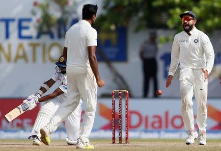 Cricket - Sri Lanka v India - First Test Match - Galle, Sri Lanka - July 29, 2017 - India's captain Virat Kohli and Ravichandran Ashwin celebrate after taking the wicket of Sri Lanka's Niroshan Dickwella (not pictured). REUTERS/Dinuka Liyanawatte