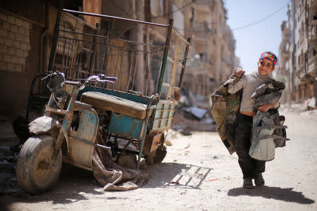 A boy walks along a damaged street at the city of Douma in Damascus, Syria, April 16, 2018. REUTERS/Omar Sanadiki