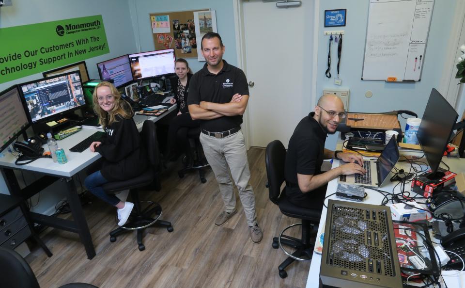 Monmouth Computer Associates owner Dan Carroll (standing) is shown with staff members (l-r): Amber Mason, Brianna Jutson & Nathan Williams at the Brick Township business Thursday, July 7, 2022. 