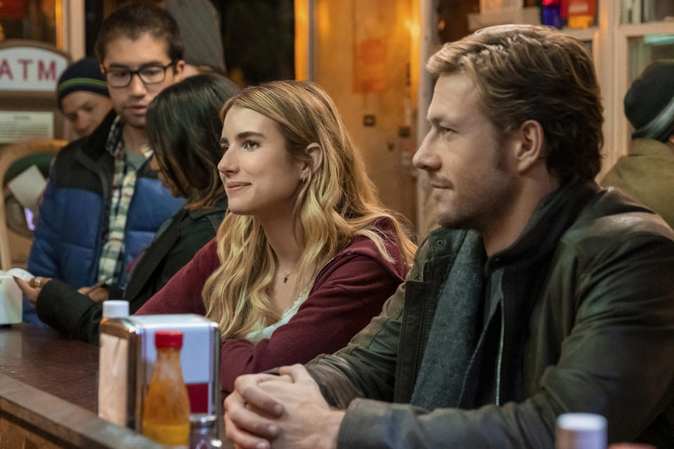 This image released by Netflix shows Emma Roberts and Luke Bracey, right, in a scene from "Holidate." (Steve Dietl/Netflix via AP)