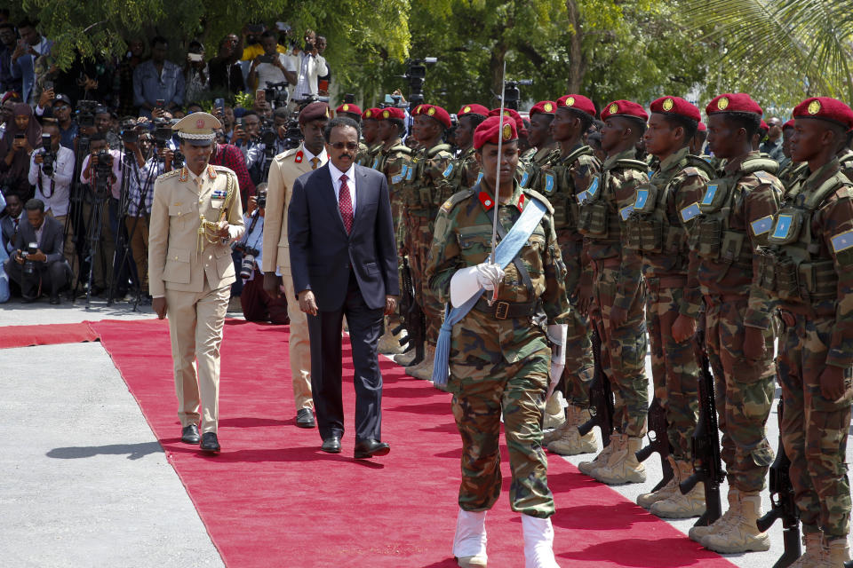 Former leader Mohamed Abdullahi Mohamed inspects a military honor guard during an official handover ceremony at the presidential palace in Mogadishu, Somalia, Monday, May 23, 2022. Hassan Sheikh Mohamud was elected to the nation's top office in a protracted contest decided by legislators on Sunday, May 15, 2022. (AP Photo/Farah Abdi Warsameh)