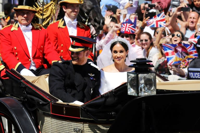 Britain's Prince Harry, Duke of Sussex and his wife Meghan, Duchess of Sussex wave from the Ascot Landau Carriage during their carriage procession on the High Street in Windsor after their wedding ceremony