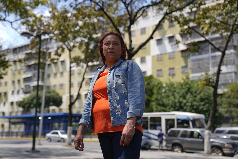 Iraida Piñero, public hospital cleaning worker, poses for a picture in a square in Caracas, Venezuela, Friday, Feb. 24, 2023. Piñero says that remittances from her daughter who migrated to Colombia with two children and makes a living selling Venezuelan-style empanadas, has kept her afloat. (AP Photo/Ariana Cubillos)