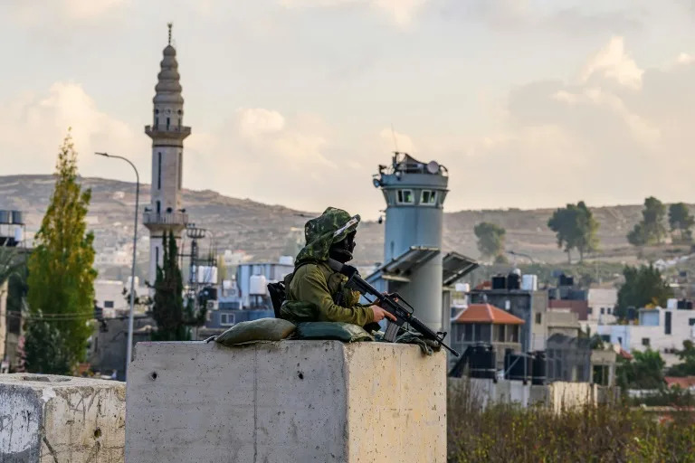 An Israeli soldier mans a checkpoint at the al-Aroub camp for Palestinian refugees south of Bethlehem in the occupied West Bank (John MACDOUGALL)