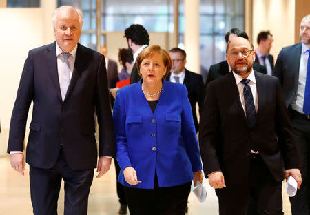 Acting German Chancellor Angela Merkel, leader of the Christian Social Union in Bavaria (CSU) Horst Seehofer and Social Democratic Party (SPD) leader Martin Schulz arrive for a press conference after exploratory talks about forming a new coalition government at the SPD headquarters in Berlin, Germany, January 12, 2018. REUTERS/Fabrizio Bensch