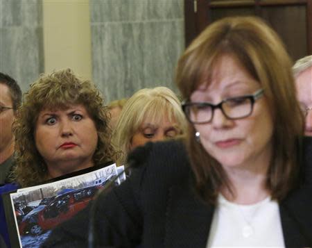 Mary Theresa Ruddy (L), whose daughter was killed in 2010 when she lost control of her 2005 Chevrolet Cobalt, holds a picture of the vehicle, as General Motors CEO Mary Barra testifies before the Senate Commerce and Transportation Consumer Protection, Product Safety and Insurance subcommittee in Washington April 2, 2014. REUTERS/Gary Cameron