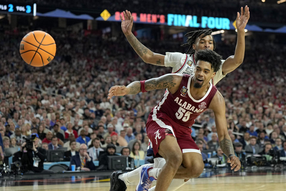 Alabama guard Aaron Estrada (55) watches the ball fall out of bounds as UConn guard Stephon Castle defends during the second half of the NCAA college basketball game at the Final Four, Saturday, April 6, 2024, in Glendale, Ariz. (AP Photo/Brynn Anderson )