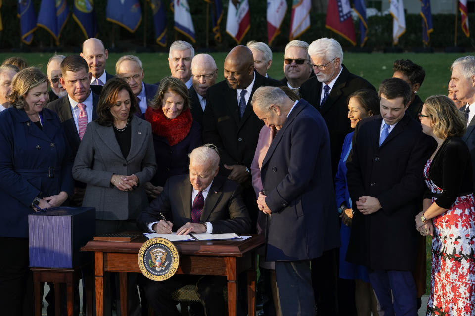 FILE - President Joe Biden signs the $1.2 trillion bipartisan infrastructure bill into law during a ceremony on the South Lawn of the White House in Washington on Nov. 15, 2021. On Friday, Nov. 19, 2021, The Associated Press reported on stories circulating online spreading falsehoods about why the presidential seal on Biden’s desk was blurred in a recent video that was shared on Vice President Kamala Harris’ Twitter account. (AP Photo/Susan Walsh, File)