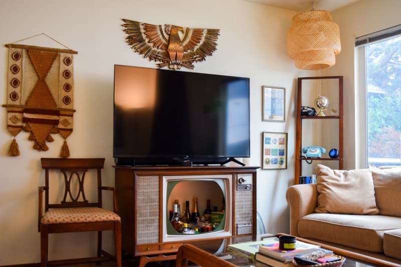 Living room with media center/bar cart combination TV stand next to a couch.