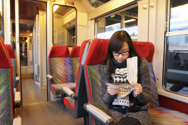 A female passenger looking the ticket on the train