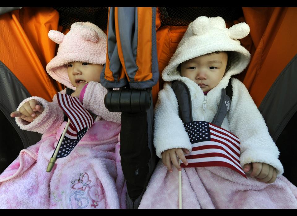 Rachel and Julia Young sleep as their mother Young Sun Kim from South Korea is sworn in during a naturalization ceremony conducted to swear in 125 new citizenship candidates at a ceremony on Liberty Island October 28, 2011 in New York to commemorate the 125th anniversary of the dedication of the Statue of Liberty.  AFP PHOTO/TIMOTHY A.CLARY (Photo credit should read TIMOTHY A. CLARY/AFP/Getty Images)