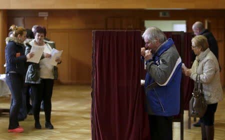 Voters prepare to cast their ballots at a polling station during the country's parliamentary election in the village of Ruzindol, Slovakia, March 5, 2016. REUTERS/David W Cerny