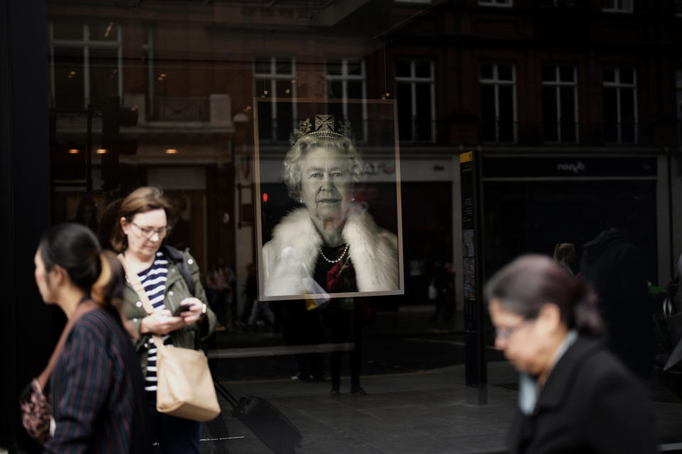 A portrait of the late Queen Elizabeth II is on display in a London shop, England, Tuesday, Sept. 13, 2022. Queen Elizabeth II, Britain's longest-reigning monarch and a rock of stability across much of a turbulent century, died Thursday Sept. 8, 2022, after 70 years on the throne. She was 96. (AP Photo/Christophe Ena)