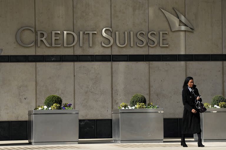 Una mujer pasa frente a la sede del banco Credit Suisse en Londres, jueves 16 de marzo de 2023. (AP Foto/Frank Augstein)