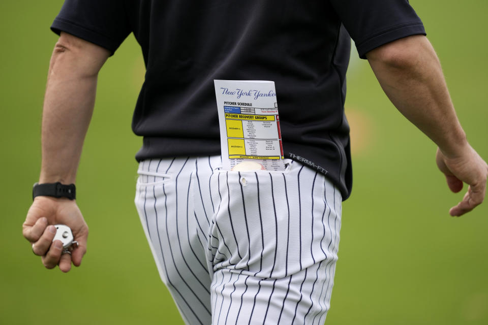 A New York Yankees assistant coach walks on the field during a baseball spring training workout Thursday, Feb. 15, 2024, in Tampa, Fla. (AP Photo/Charlie Neibergall)