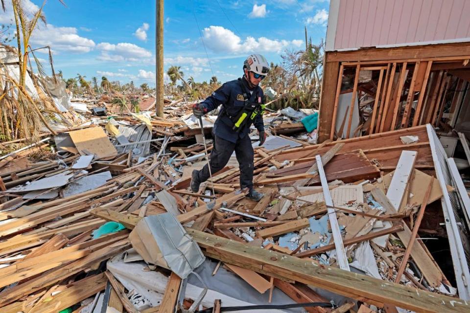 R. Martin, miembro del equipo de Búsqueda y Rescate Urbano de la Florida, busca en casas dañadas en Fort Myers Beach, el lunes 3 de octubre de 2022.