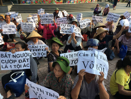 Farmers from Duong Noi village protest outside a court during a trial of Can Thi Theu, a farmer and land protection activist in Hanoi, Vietnam September 20, 2016. The placards read "Can Thi Theu is innocent", "Freedon for Can Thi Theu" and "make arrest - grabbing land is criminal". REUTERS/Nguyen Tien Thinh
