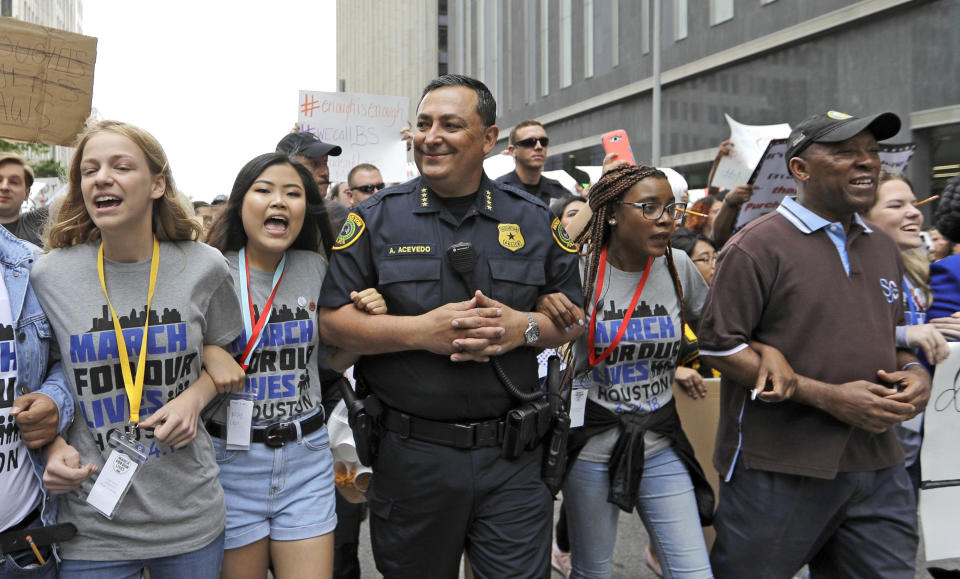 FILE - Houston Police Chief Art Acevedo, center, and Houston Mayor Sylvester Turner, far right, join demonstrators during a "March for Our Lives" protest for gun legislation and school safety Saturday, March 24, 2018, in Houston. The National Rifle Association is going ahead with its annual meeting in Houston just days after the shooting massacre at a Texas elementary school that left 19 children and 2 teachers dead. With protests planned outside, former President Donald Trump and other leading GOP figures, including South Dakota Gov. Kristi Noem, will address attendees. (AP Photo/David J. Phillip, File)