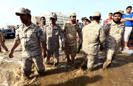 Members of Saudi security forces walk through a flooded street following heavy rain in Jeddah, Saudi Arabia November 17, 2015. REUTERS/Mohamed Al Hwaity