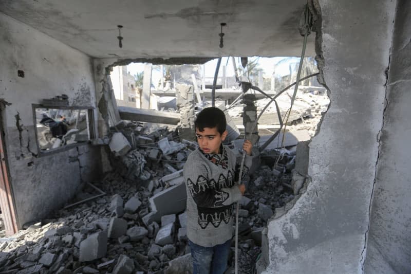 A Palestinian child inspects the damage caused by an Israeli air strike on several buildings in Deir al-Balah in central Gaza Strip. Mohammed Talatene/dpa