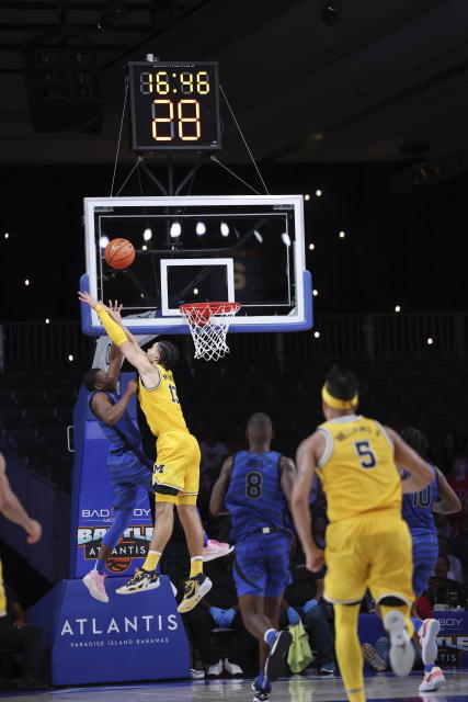 Memphis's Jayhlon Young, left, shoots the ball as Michigan's Olivier Nkamhoua blocks during the second half of an NCAA college basketball game in the Battle 4 Atlantis at Paradise Island, Bahamas, Wednesday, Nov. 22, 2023. (Tim Aylen/Bahamas Visual Services via AP)