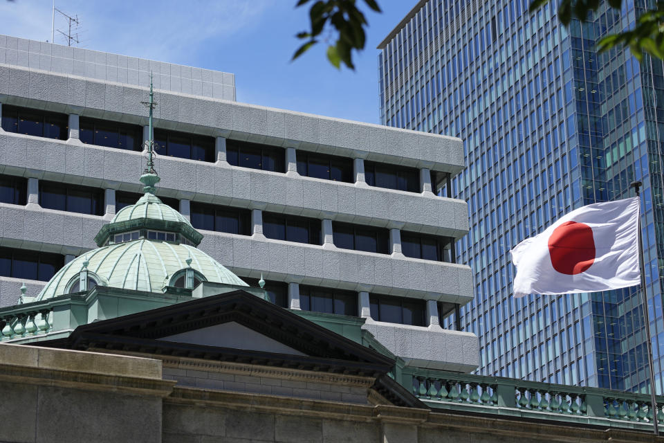 FILE - A Japanese flag flutters at the Bank of Japan headquarters in Tokyo, Thursday, July 29, 2022. Japan’s central bank opted Friday, July 28, 2023, to keep its benchmark interest rate at minus 0.1% but said it will fine-tune its bond purchases to allow greater flexibility. (AP Photo/Shuji Kajiyama, File)