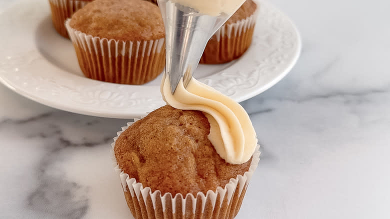 piping cupcakes with caramel frosting