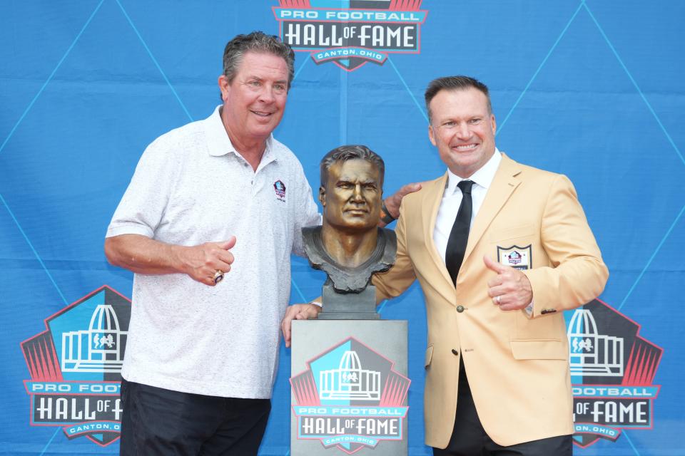 Miami Dolphins linebacker Zach Thomas poses with his bust and quarterback Dan Marino during Saturday's 2023 Pro Football Hall of Fame Enshrinement at Tom Benson Hall of Fame Stadium in Canton, Ohio.