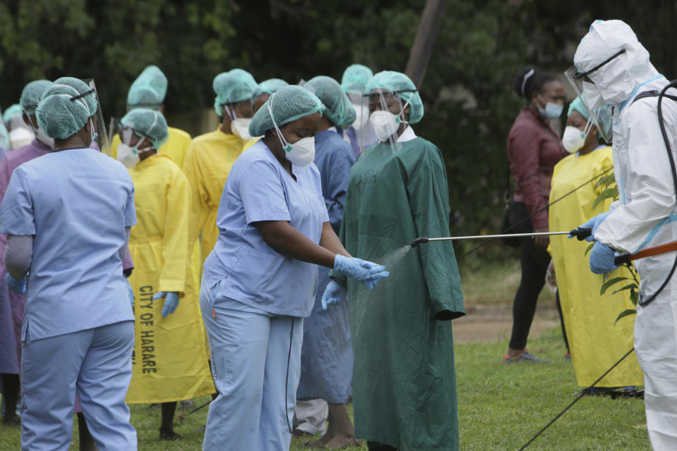 Health workers are sanitized at local hospital where China's Sinopharm vaccine is being administered at a local hospital in Harare, Thursday, Feb, 18, 202. Zimbabwean Deputy President Constantino Chiwenga became the first person in the country to receive the jab marking the first phase of the countrys vaccination campaign.(AP Photo/Tsvangirayi Mukwazhi)