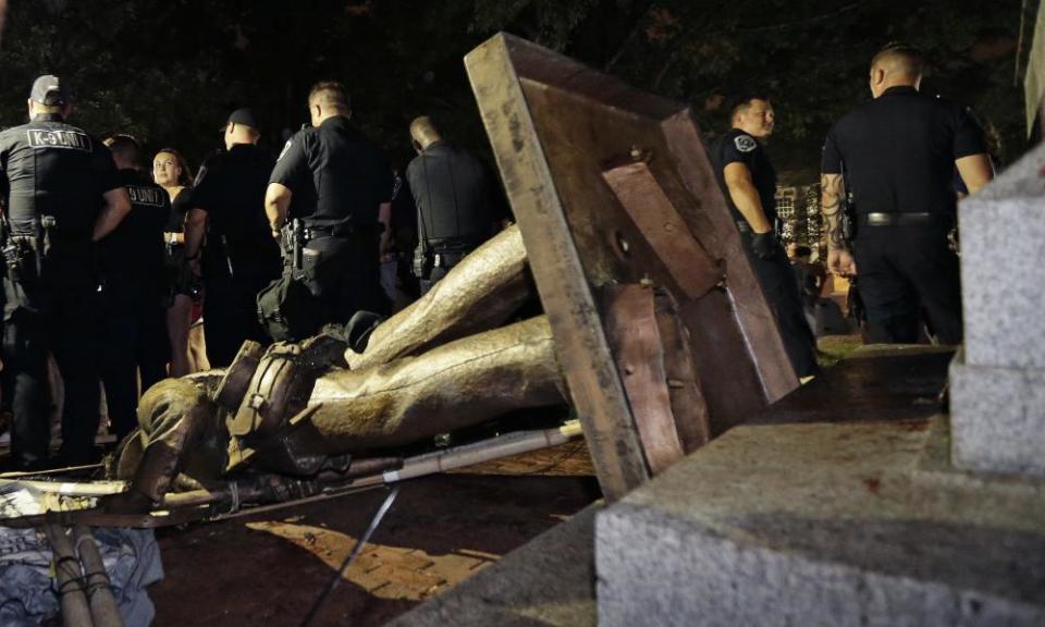 Police stand guard after the Confederate statue known as ‘Silent Sam’ was toppled by protesters.