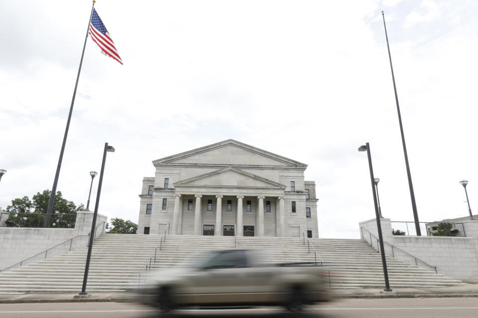 The Mississippi state flag was missing from its pole to the right of the American flag, outside the Carroll Gartin Justice Building in Jackson, Miss., Monday, June 29, 2020, the day after both chambers of the state Legislature passed a bill to take down and replace the current flag, which contains the Confederate battle emblem. (AP Photo/Rogelio V. Solis)