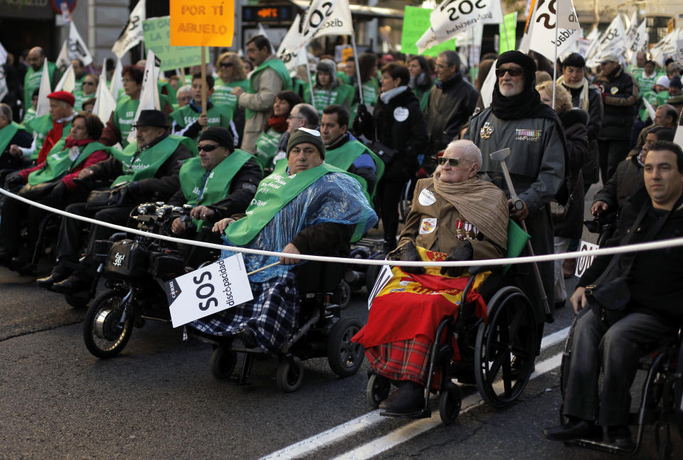 People march on wheelchairs as they carry banners reading, "SOS, disability" during a protest against government austerity measures affecting disabled people by reducing services, closing disability centers and forcing care workers from their jobs in Madrid, Spain, Sunday, Dec. 2, 2012. More than 10,000 people, many in wheelchairs or being led by guide dogs, marched in a demonstration with the slogan "SOS Disability: Save our Rights, Inclusion and Welfare." Health care spending falls under the responsibility of regional governments, many of which are indebted. Some local administrations have failed to pay medical centers, forcing cuts in services and a slow-down in the distribution of medicine. (AP Photo/Andres Kudacki)