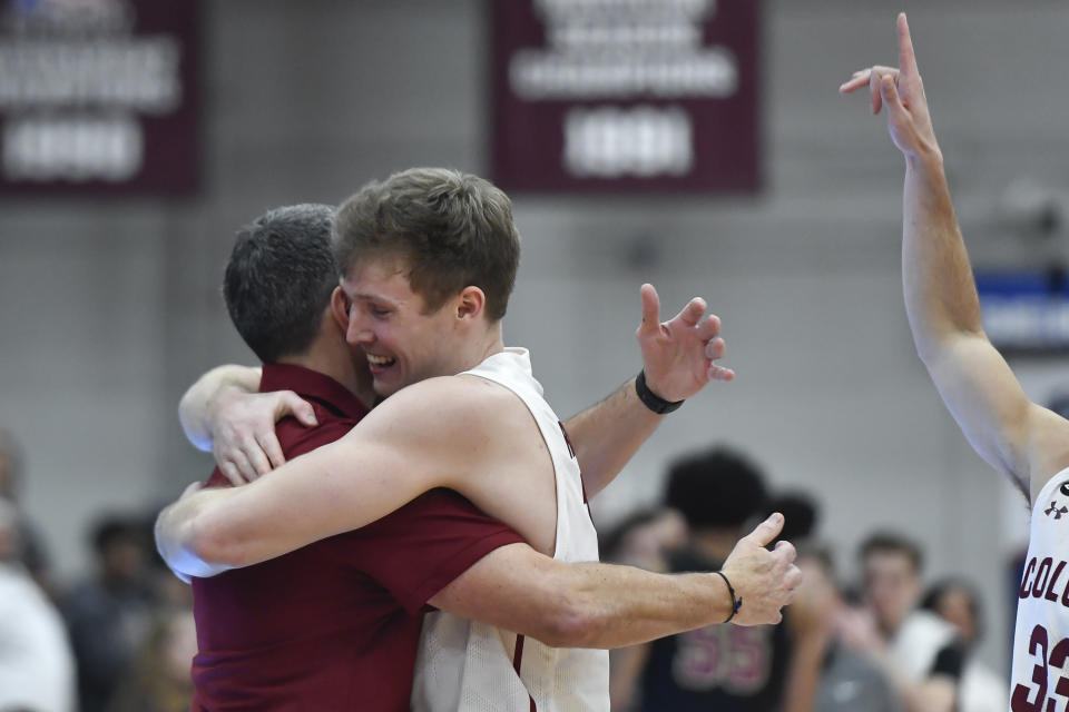 Colgate guard Tucker Richardson hugs head coach Matt Langel during the second half of an NCAA college basketball game against Lafayette for the Patriot League tournament championship in Hamilton, N.Y., Wednesday, March 8, 2023. (AP Photo/Adrian Kraus)