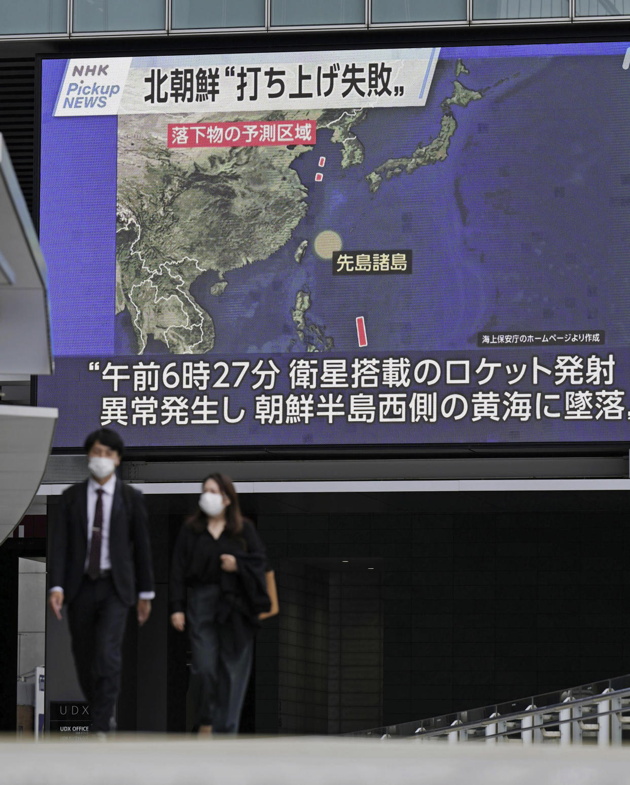 People walk near a huge screen with a news report of a North Korea's rocket launch, in Tokyo Wednesday, May 31, 2023. North Korea said its attempt to put the country’s first spy satellite into orbit failed Wednesday, an apparent embarrassment to leader Kim Jong Un over his push to boost his military capability in the protracted security tensions with the United States and South Korea. The words, top, read "North Korea's launch failed." (Kyodo News via AP)