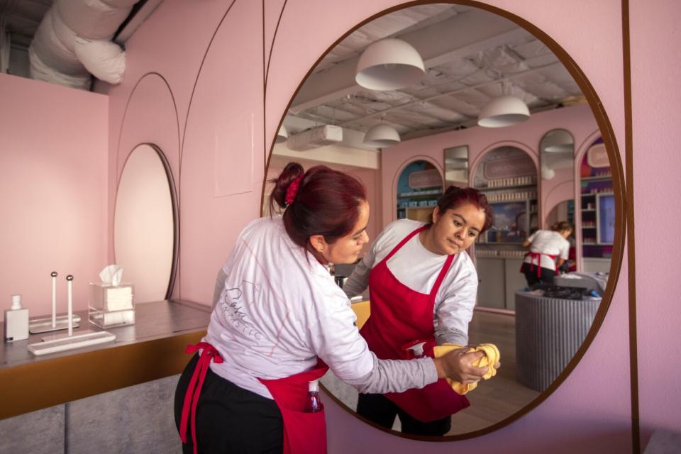 Erika Mijangos cleans a mirror at a commercial business